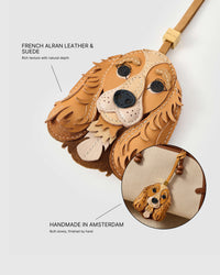 Close-up of handmade Cocker Spaniel leather bag charm — French Alran genuine leather and suede with rich texture, hand-stitched edges, 18K gold-plated hardware. STICKYZOO collectible.