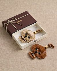 Brown and cream poodle charms in ribbon-tied gift box — French Alran goatskin, alcantara suede, 72 hours of handcraft per piece.