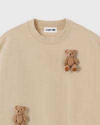 Close-up of dual plush teddy bear appliques on cream 450gsm cotton fleece showing 3D texture