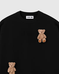 Close-up of dual plush teddy bears on black 450gsm cotton fleece showing contrast and 3D layered texture