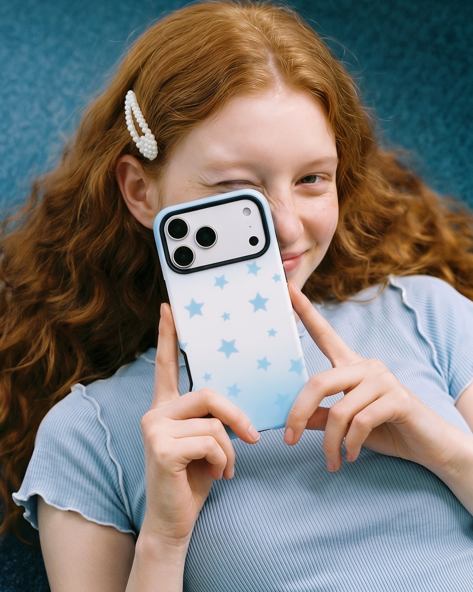 Sky-star phone case held up to take a photo, the full blue star print and camera cutout in view