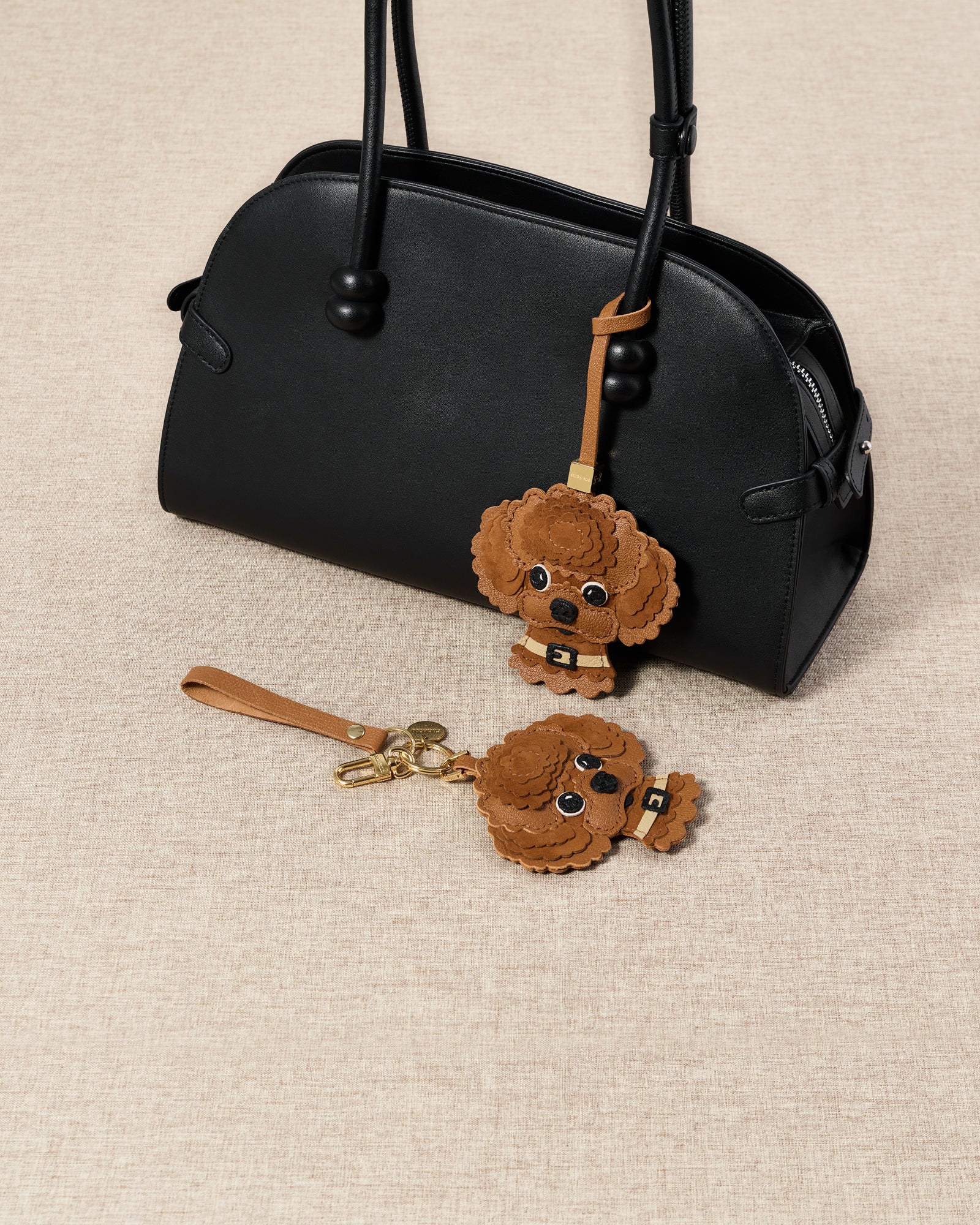 {{Keychain edition.}} The Poodle Charm on an 18K gold-plated keychain clip with engraved STICKYZOO disc — clips to keys, bags or backpacks.