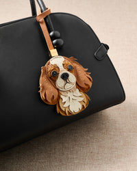 STICKYZOO Cavalier King Charles charm on black handbag — the face that makes strangers stop and ask.