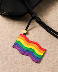 Pride rainbow flag leather charm hanging from black bag — six hand-cut French Alran goatskin layers