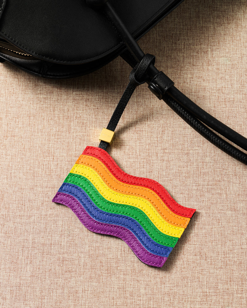 Pride rainbow flag leather charm hanging from black bag — six hand-cut French Alran goatskin layers