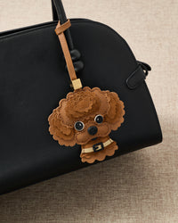on bag — rated 4.9★ by thousands. Scalloped French Alran leather and alcantara suede curls with 18K gold-plated cube.