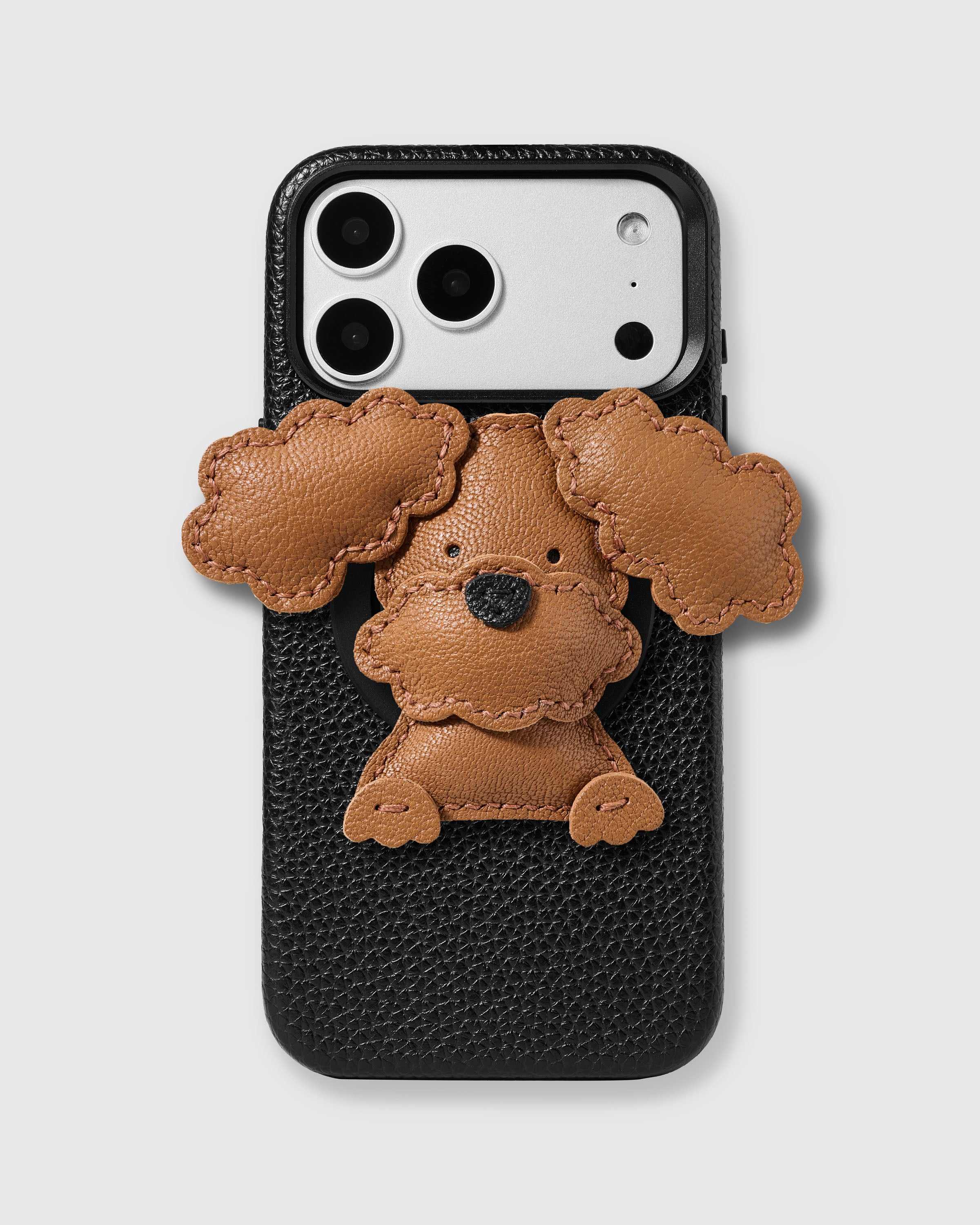STICKYZOO Poodle Puppy Charm Case in black with 3D handmade French Alran leather poodle puppy charm featuring tan body, floppy scalloped ears, black nose, and little front paws.