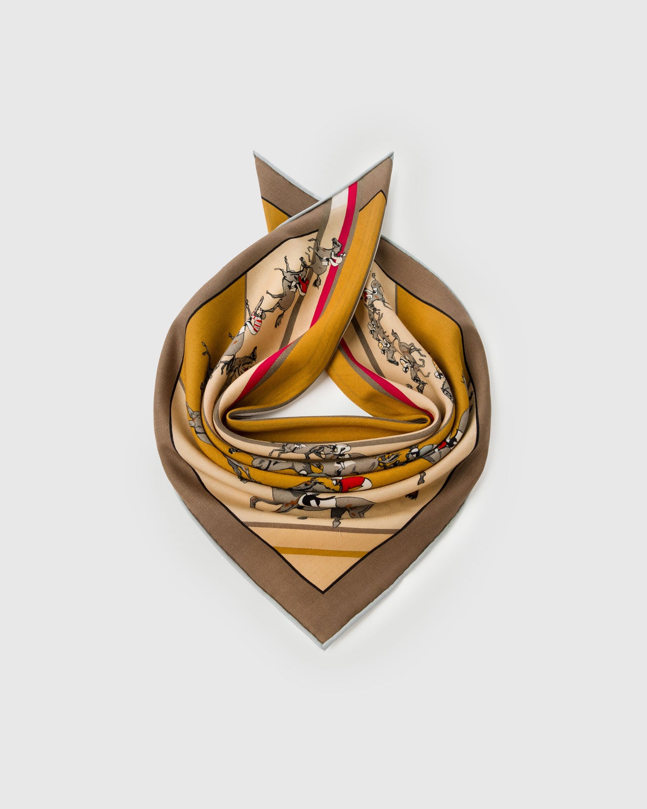 Silk scarf coiled to show the soft drape and the mustard and red derby print holding saturated color