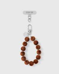 Camel-brown velvet pom bead phone strap with silver-tone engraved hardware by STICKYZOO