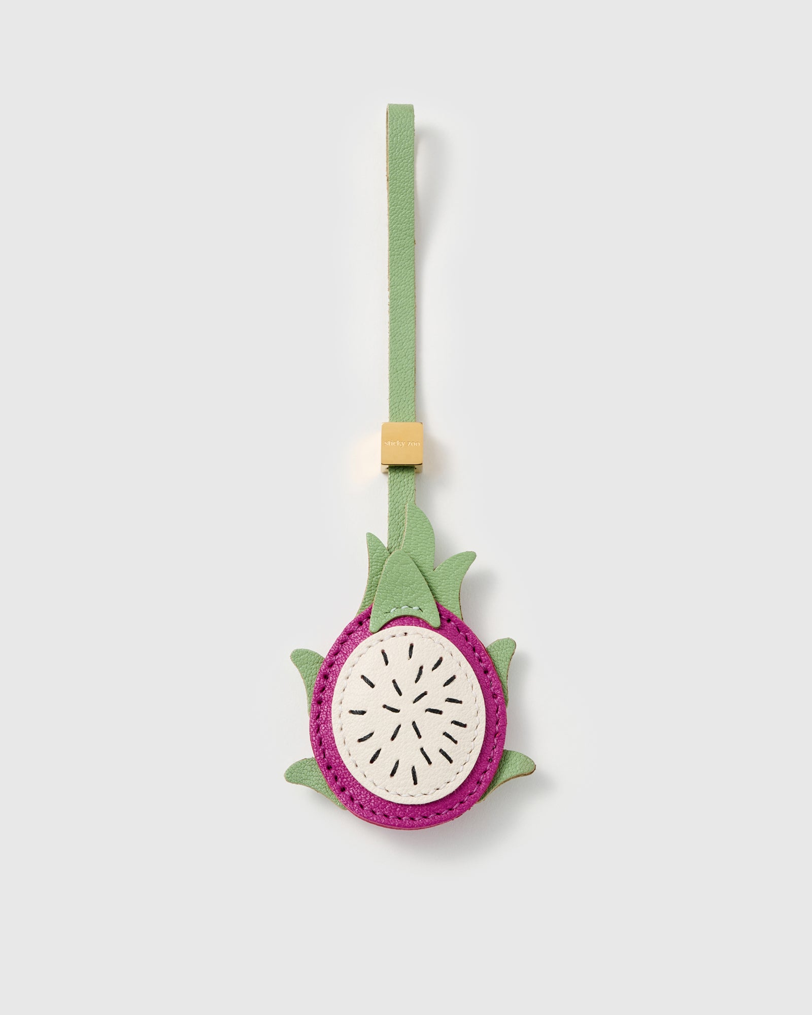 Handmade pitaya dragon fruit bag charm in French Alran leather with hand-stitched black seeds and 18K gold-plated cube by STICKYZOO