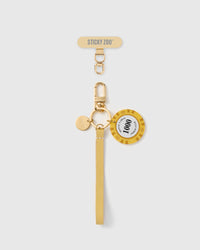 Handmade French Alran saffron yellow leather phone strap with vintage-style translucent yellow chip charm and 18K gold STICKYZOO hardware