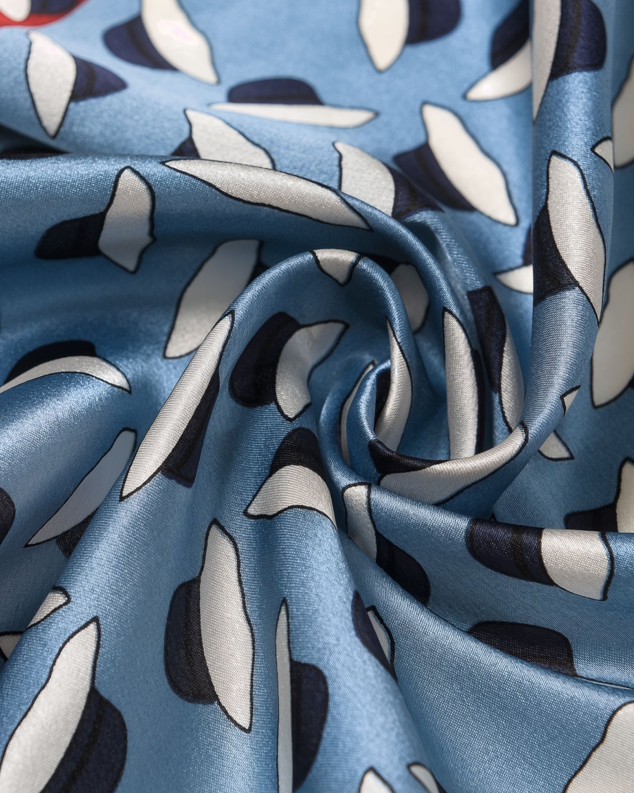 Close-up of the hand-illustrated petal motif in navy and ivory across the sky-blue silk field
