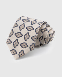 STICKYZOO Pearl Amoeba Tie in hand-embroidered mulberry silk with organic navy medallions on pearl herringbone ground, 45° bias-cut