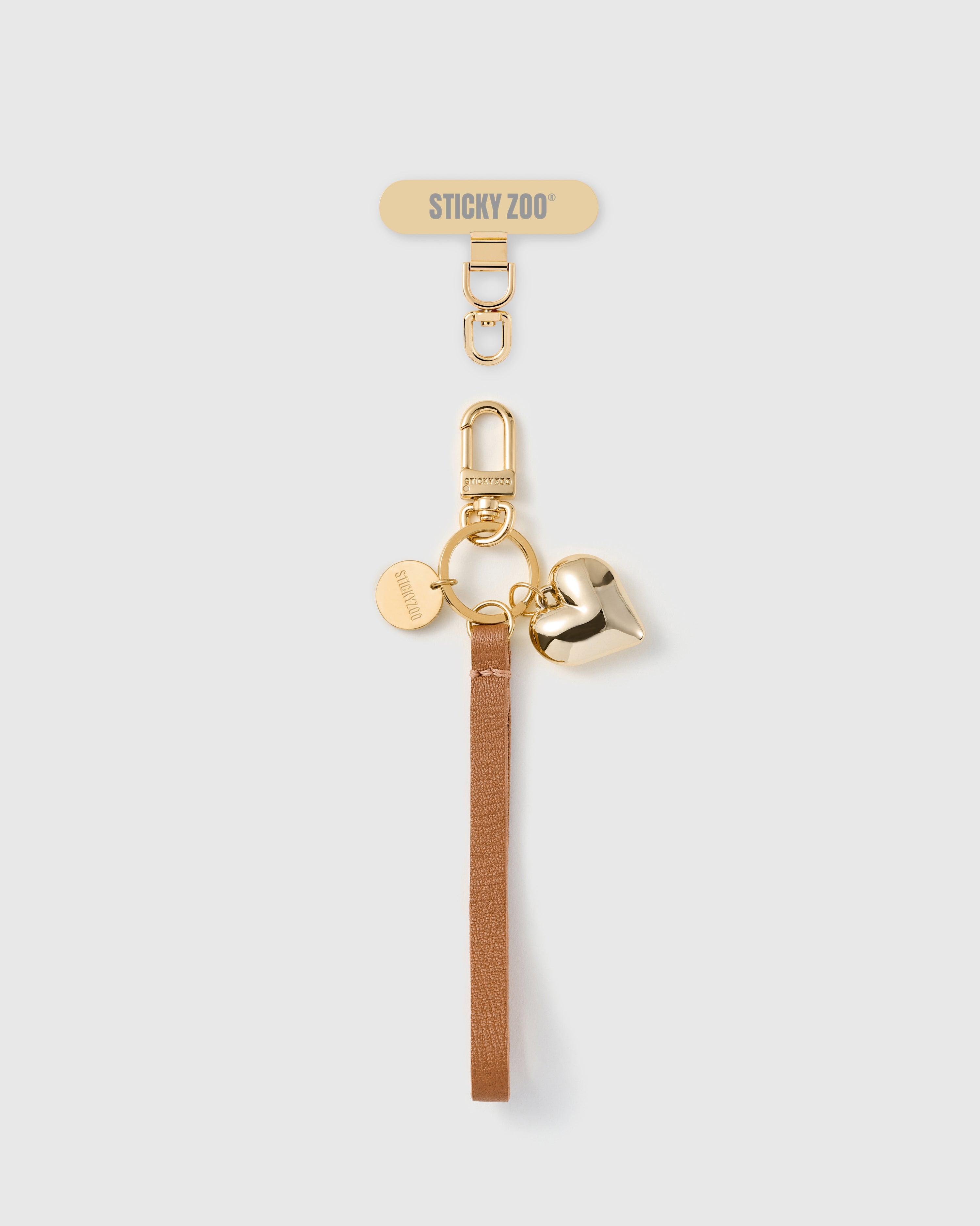 Handmade French Alran cocoa tan leather phone strap with polished gold-plated puff heart charm and 18K gold STICKYZOO hardware