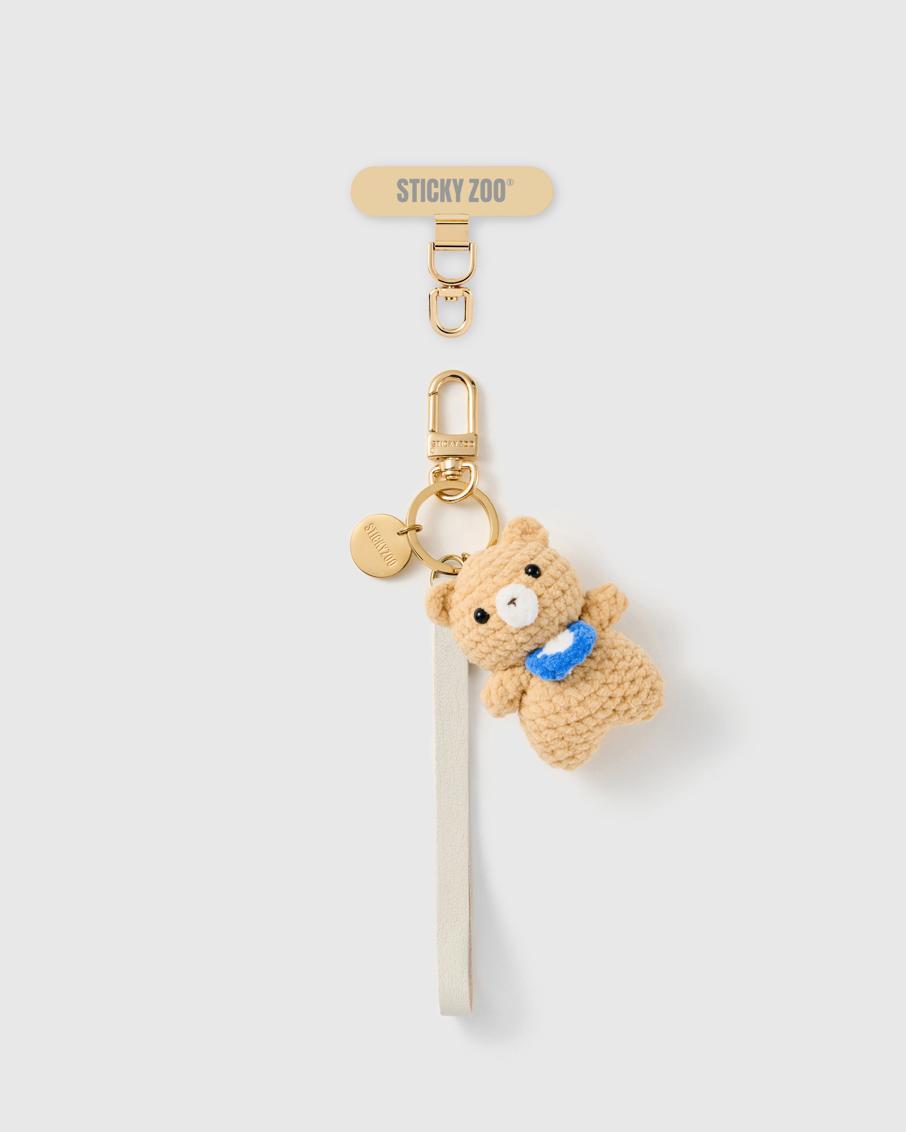 Handmade French Alran ivory leather phone strap with hand-crochet camel teddy and blue scarf charm, 18K gold STICKYZOO hardware