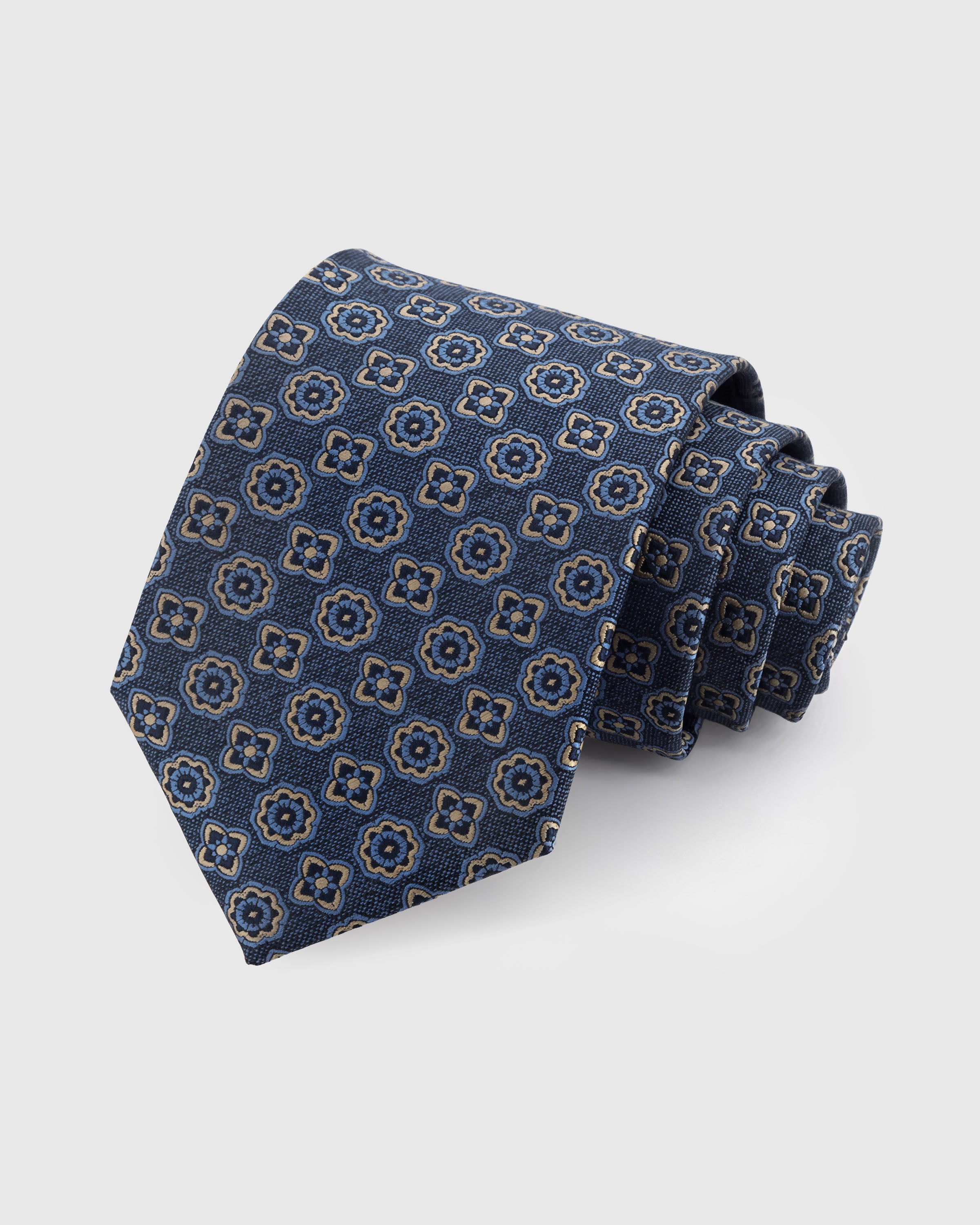 STICKYZOO DENIM ROSETTE TIE — 100% mulberry silk with hand-embroidered gold-outlined rosette and clover motifs on washed denim blue ground