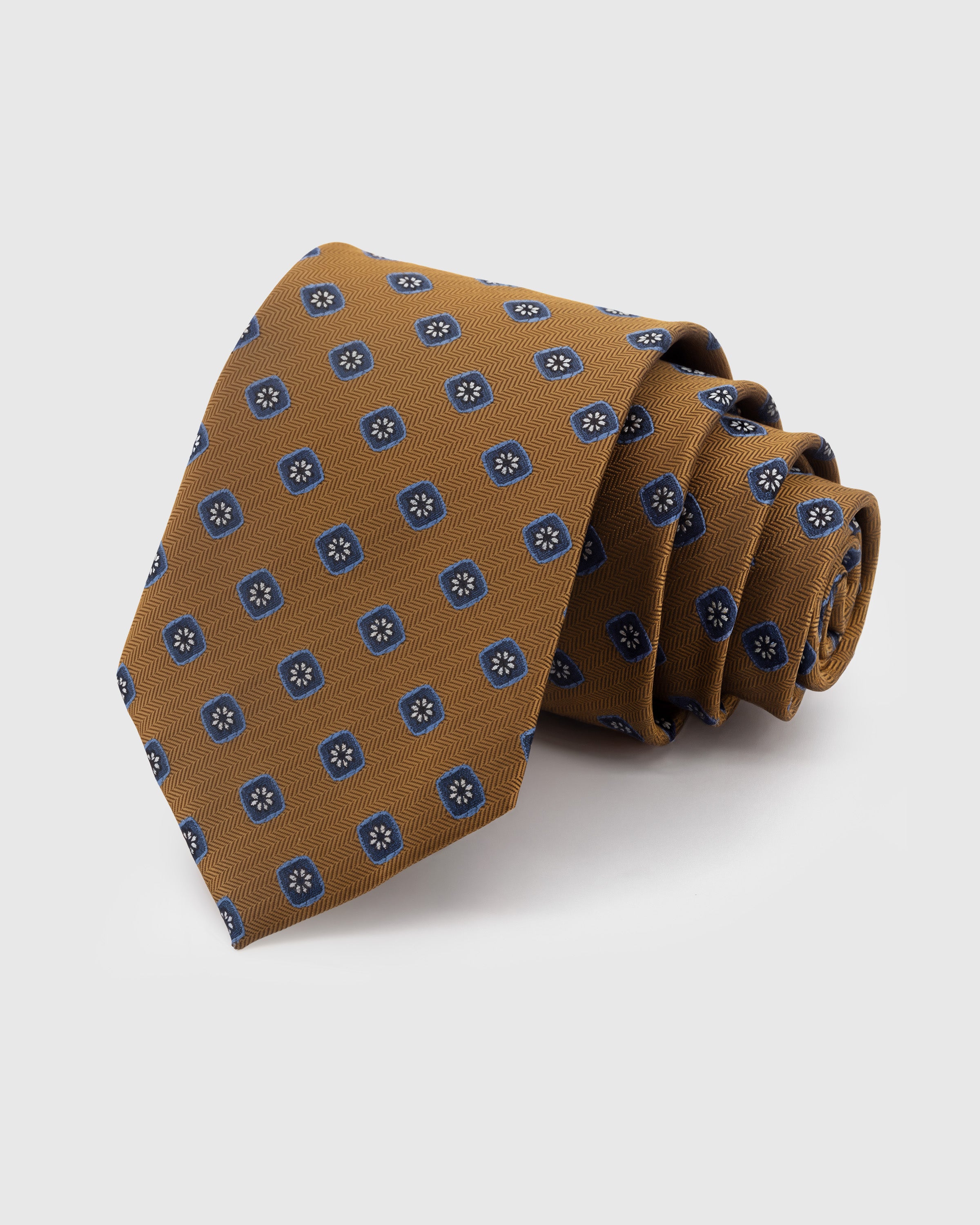 STICKYZOO Amber Floral Square Tie in hand-embroidered mulberry silk with navy floret motifs on herringbone ground, 45° bias-cut Italian method