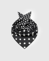 Silk polka scarf rolled into a soft bloom showing the small-square drape and the mix of dot scales