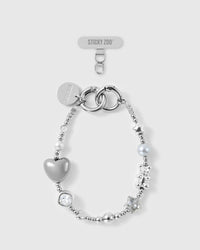 STICKYZOO Moonlight silver beaded phone wrist strap laid flat, showing puff heart, stars, teddy, grey pearl-effect bead, clear bead and engraved disc