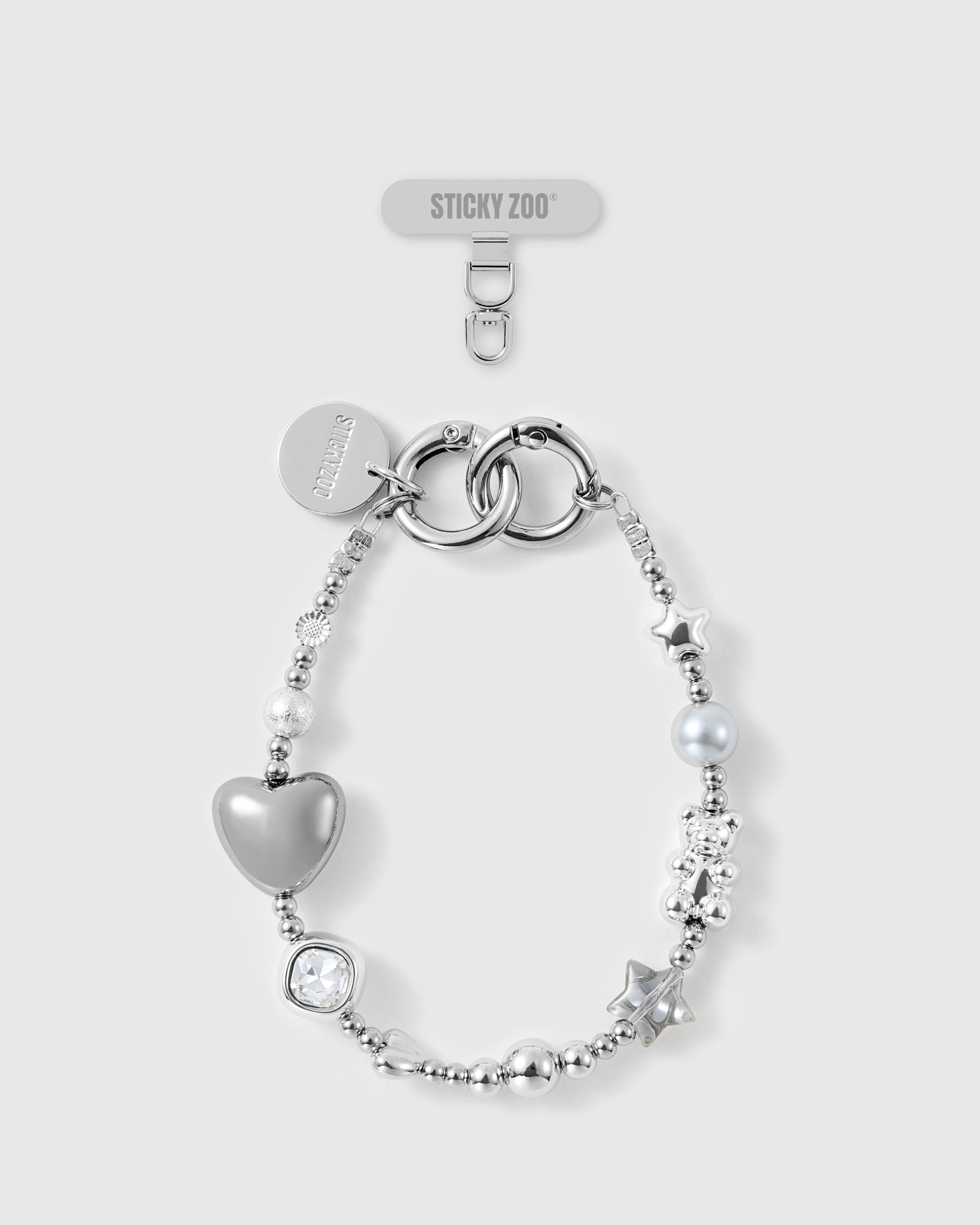 STICKYZOO Moonlight silver beaded phone wrist strap laid flat, showing puff heart, stars, teddy, grey pearl-effect bead, clear bead and engraved disc