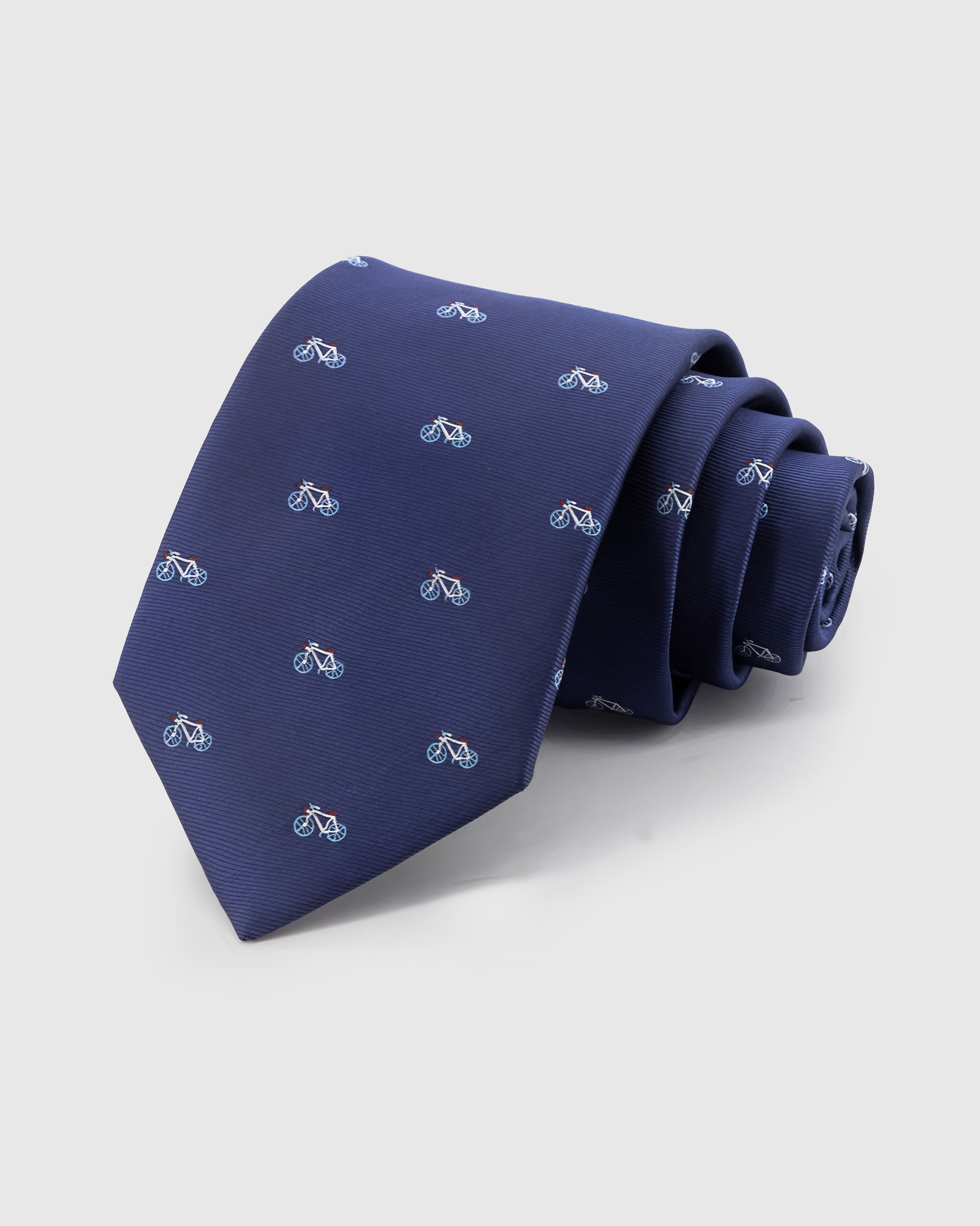 NAVY BICYCLE TIE — Hand-embroidered bicycle detail on 100% mulberry silk in navy, showing embroidery texture and silk sheen