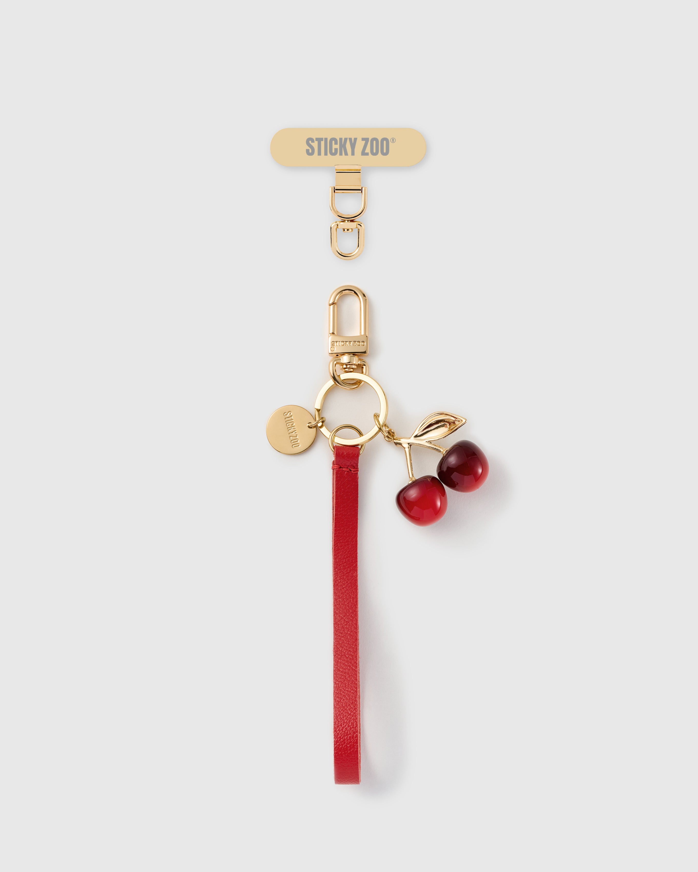Handmade French Alran crimson red leather phone strap with glossy dark red cherry pair charm and 18K gold STICKYZOO hardware