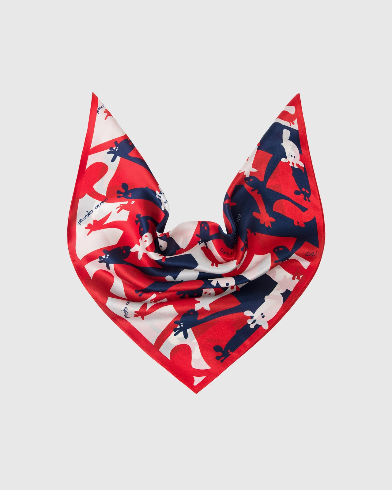 Silk scarf draped to show the soft fall and the pop-art giraffe print holding saturated red and navy