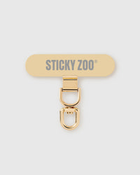STICKYZOO Phone Strap Card — slim universal connector tab with a gold-tone swivel clasp that clips any phone strap to any phone.