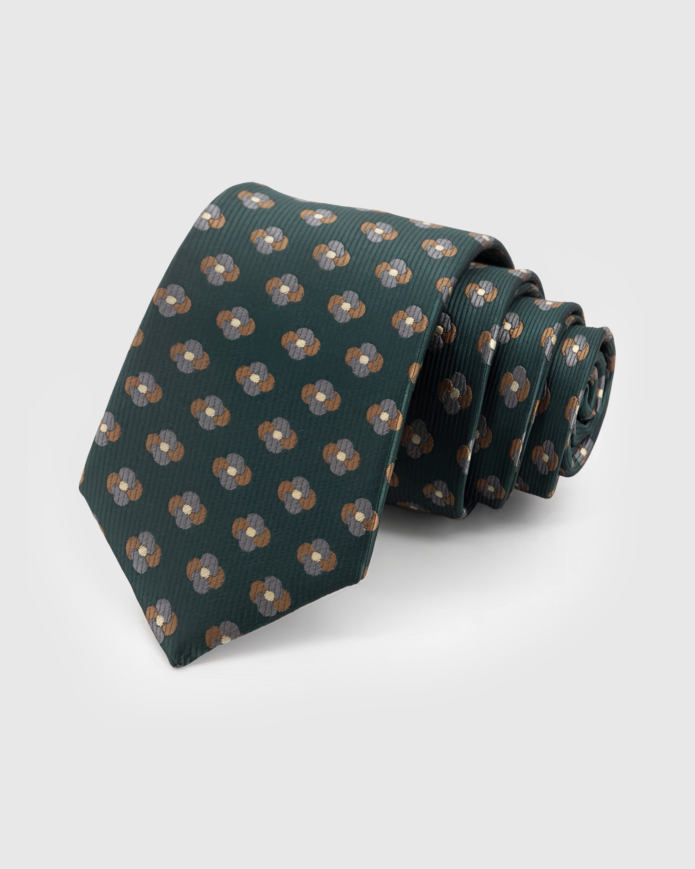 STICKYZOO Pine Clover Tie in hand-embroidered mulberry silk with bronze and silver clover motifs on deep forest green ground, 45° bias-cut