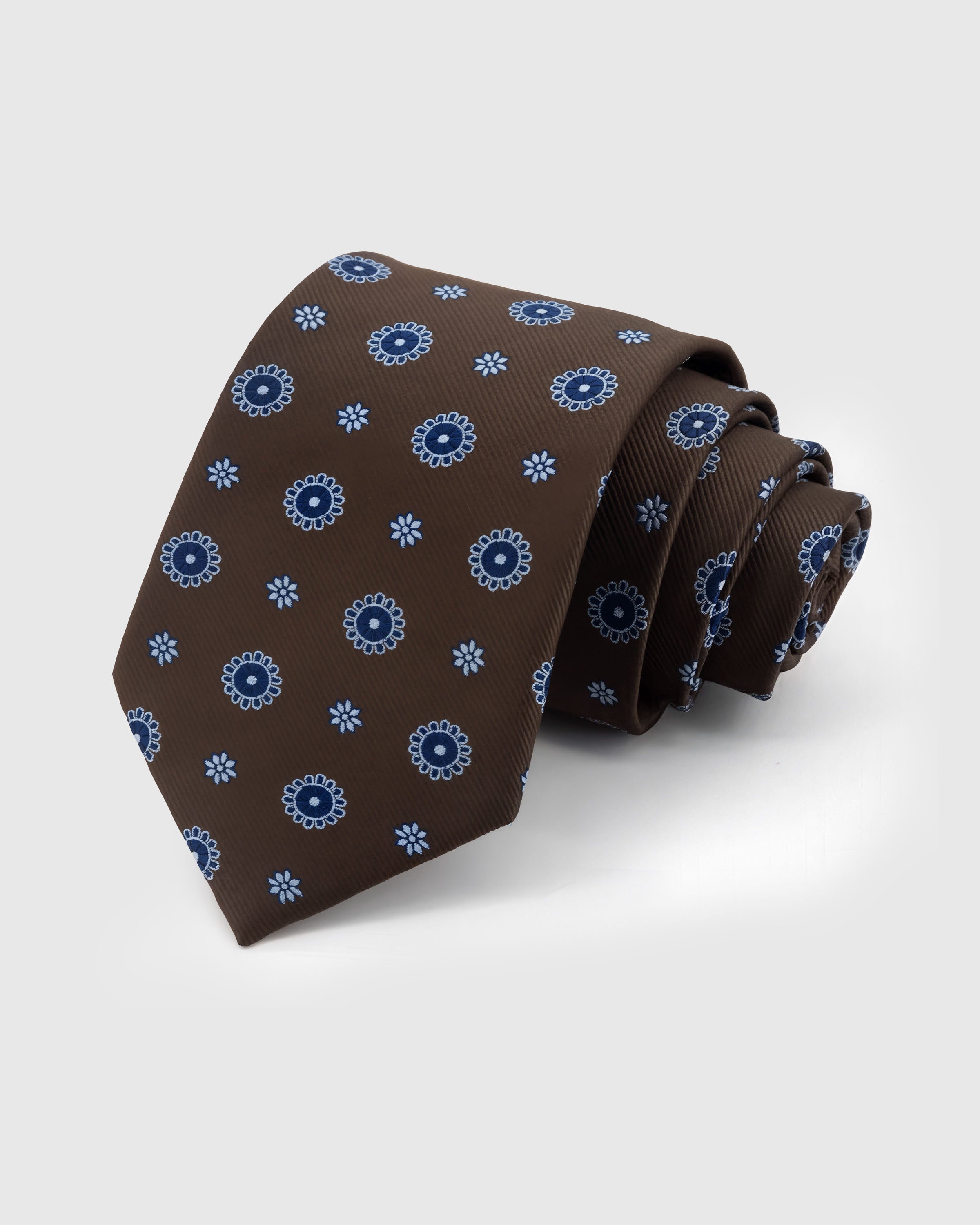 STICKYZOO Mocha Sunburst Tie in hand-embroidered mulberry silk with periwinkle sunburst medallions on mocha ground, 45° bias-cut Italian method