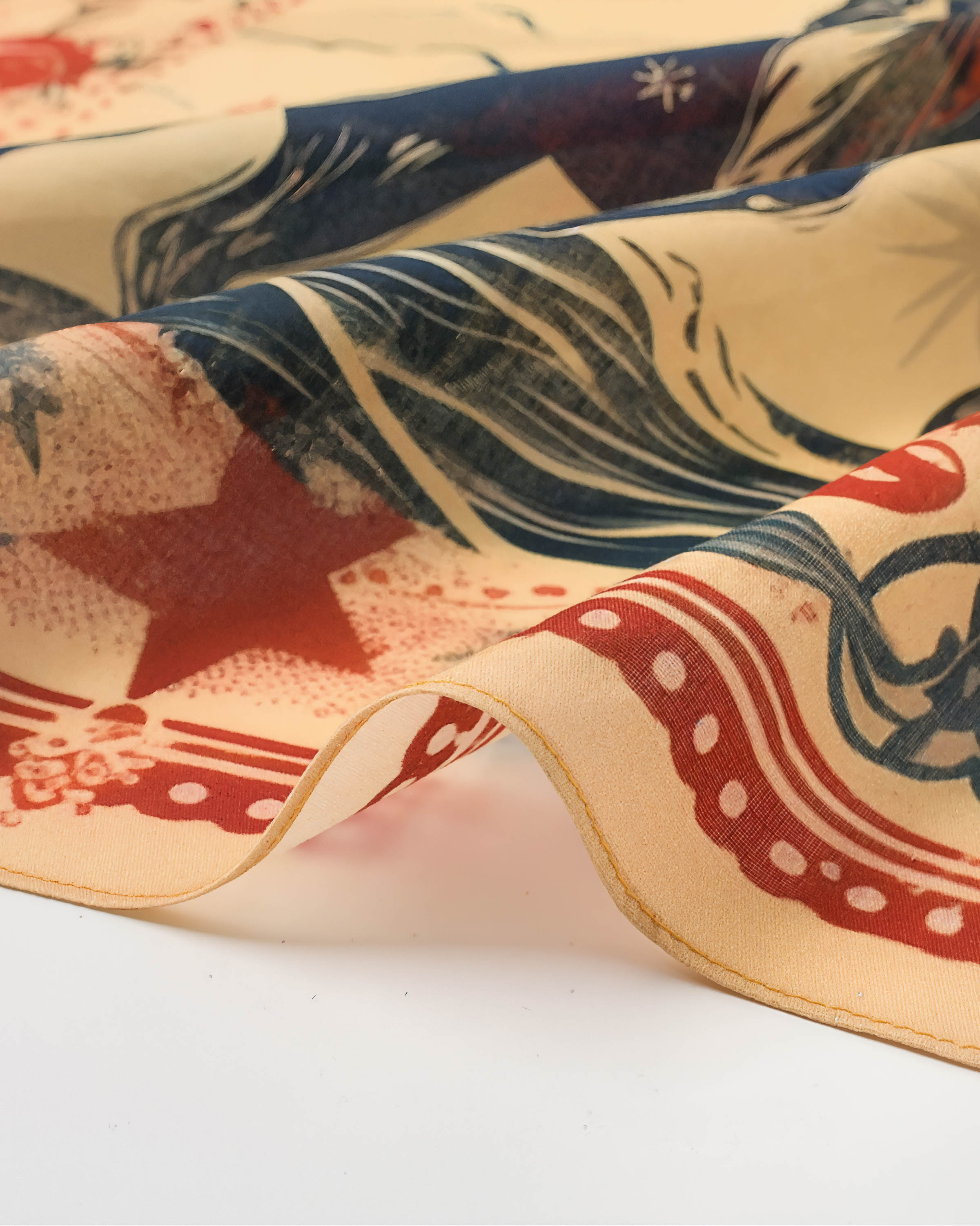 Close-up of the cowgirl silk scarf showing the soft drape of pure silk and the inked navy print