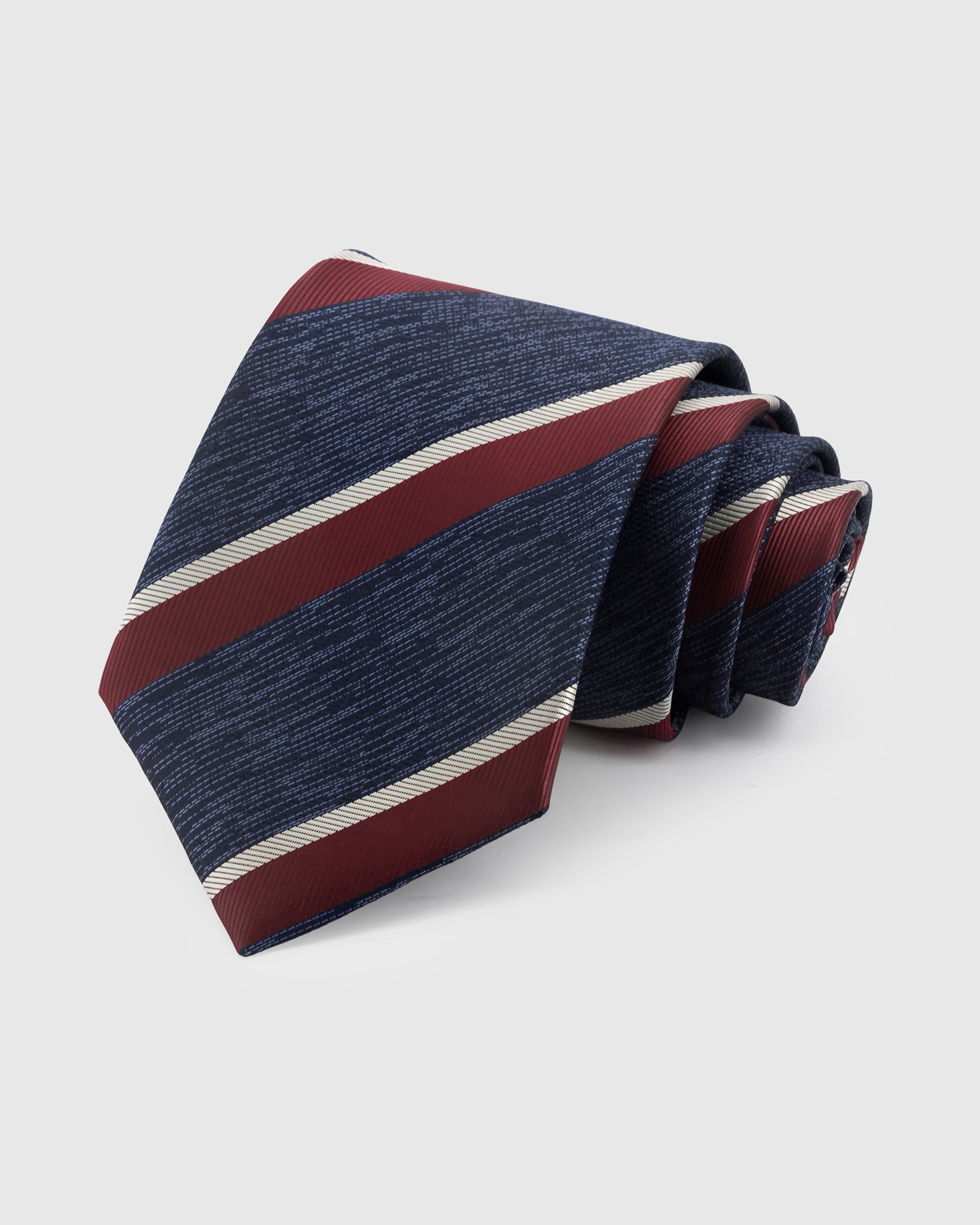 NAVY BORDEAUX STRIPE TIE — Hand-embroidered regimental stripe detail on 100% mulberry silk in navy, showing embroidery texture and silk sheen