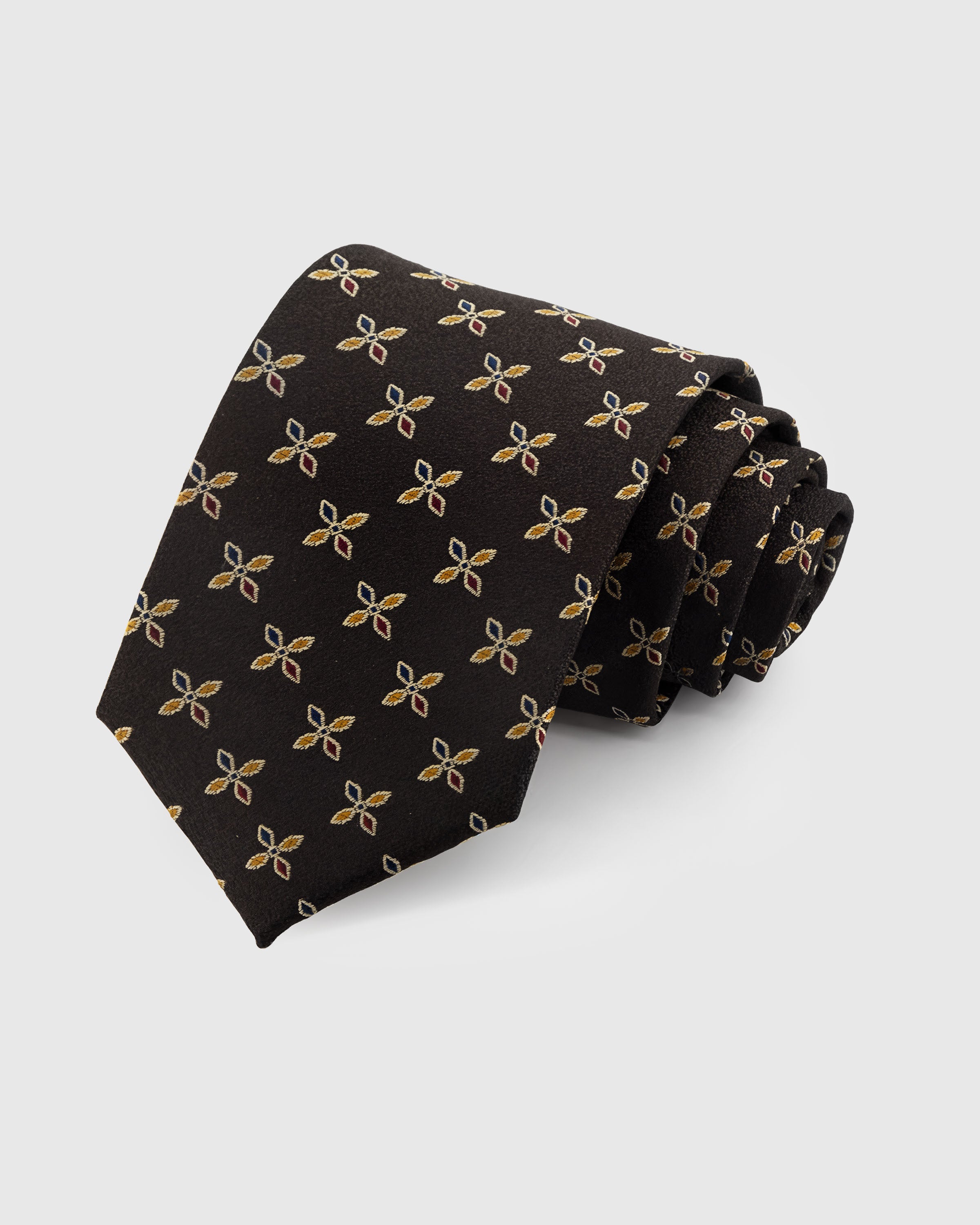 STICKYZOO ONYX PETAL TIE — 100% mulberry silk with hand-embroidered gold and russet four-petal leaf motifs on deep onyx black ground