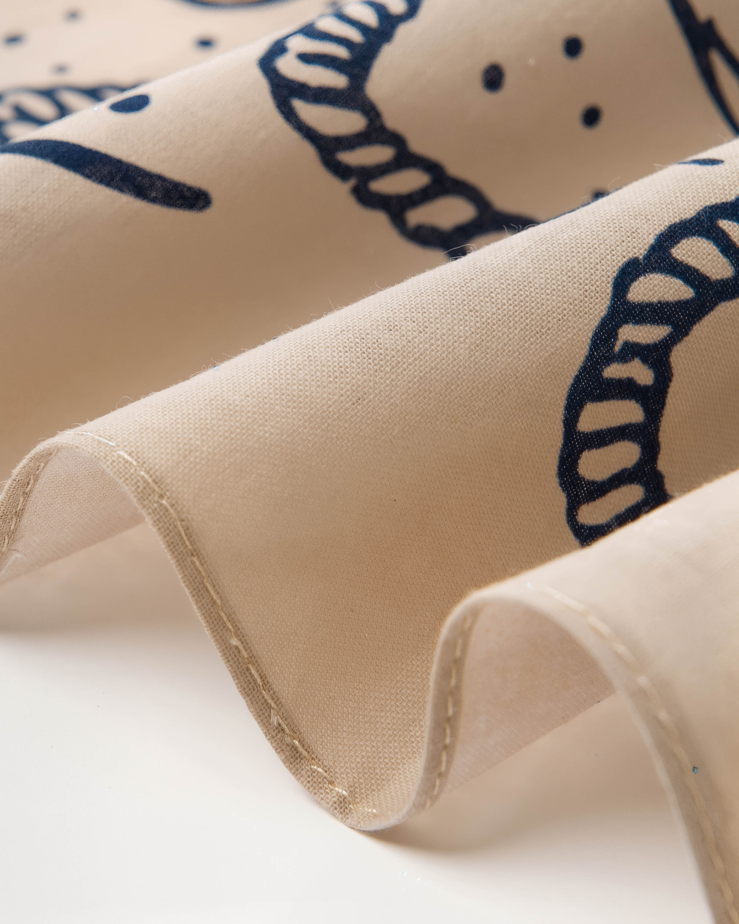 Close-up of the rope-loop print on the desert outlaw silk scarf showing the soft drape of pure silk