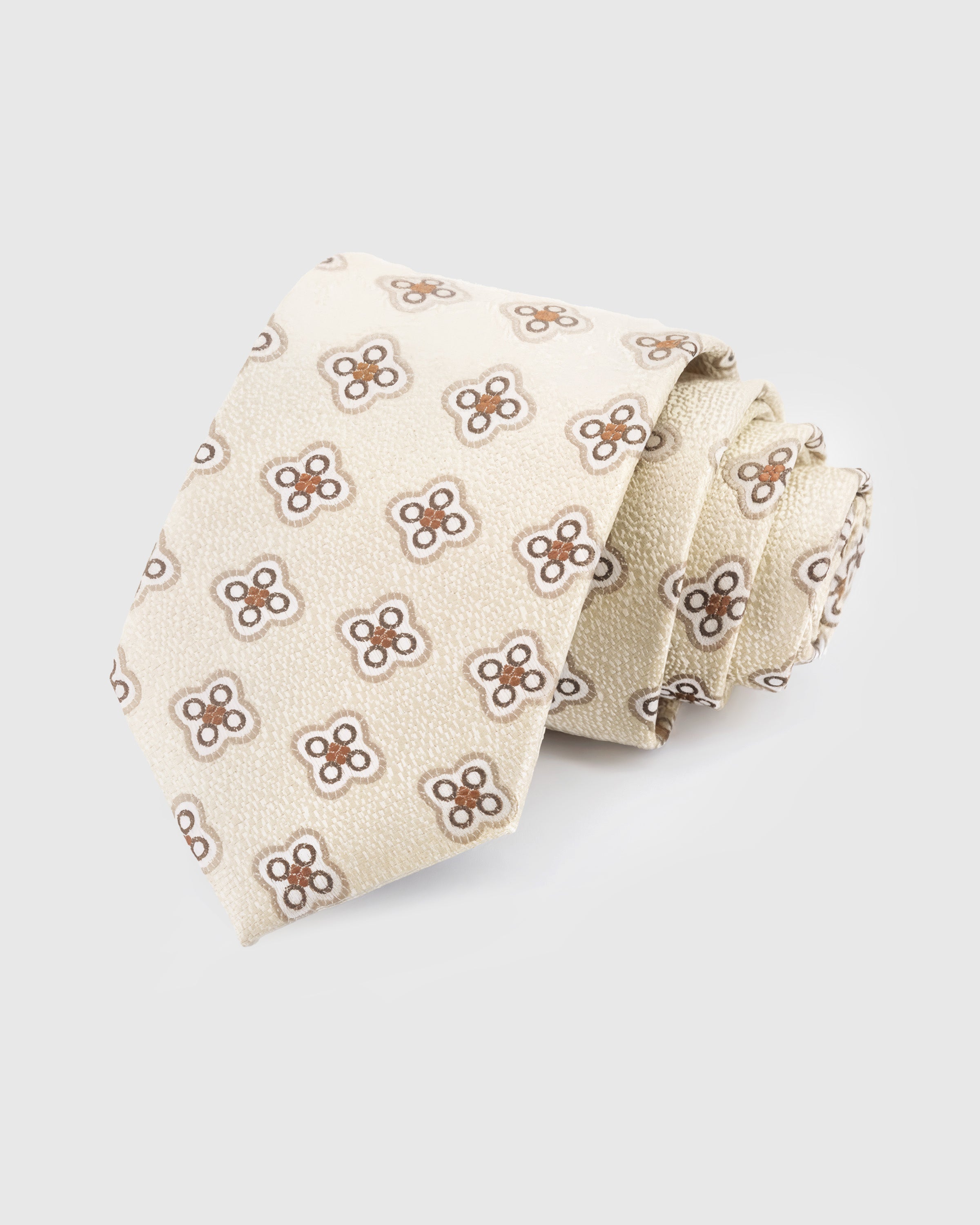 STICKYZOO Ivory Medallion Tie in hand-embroidered mulberry silk with sienna quatrefoil medallions on textured cream ground, 45° bias-cut