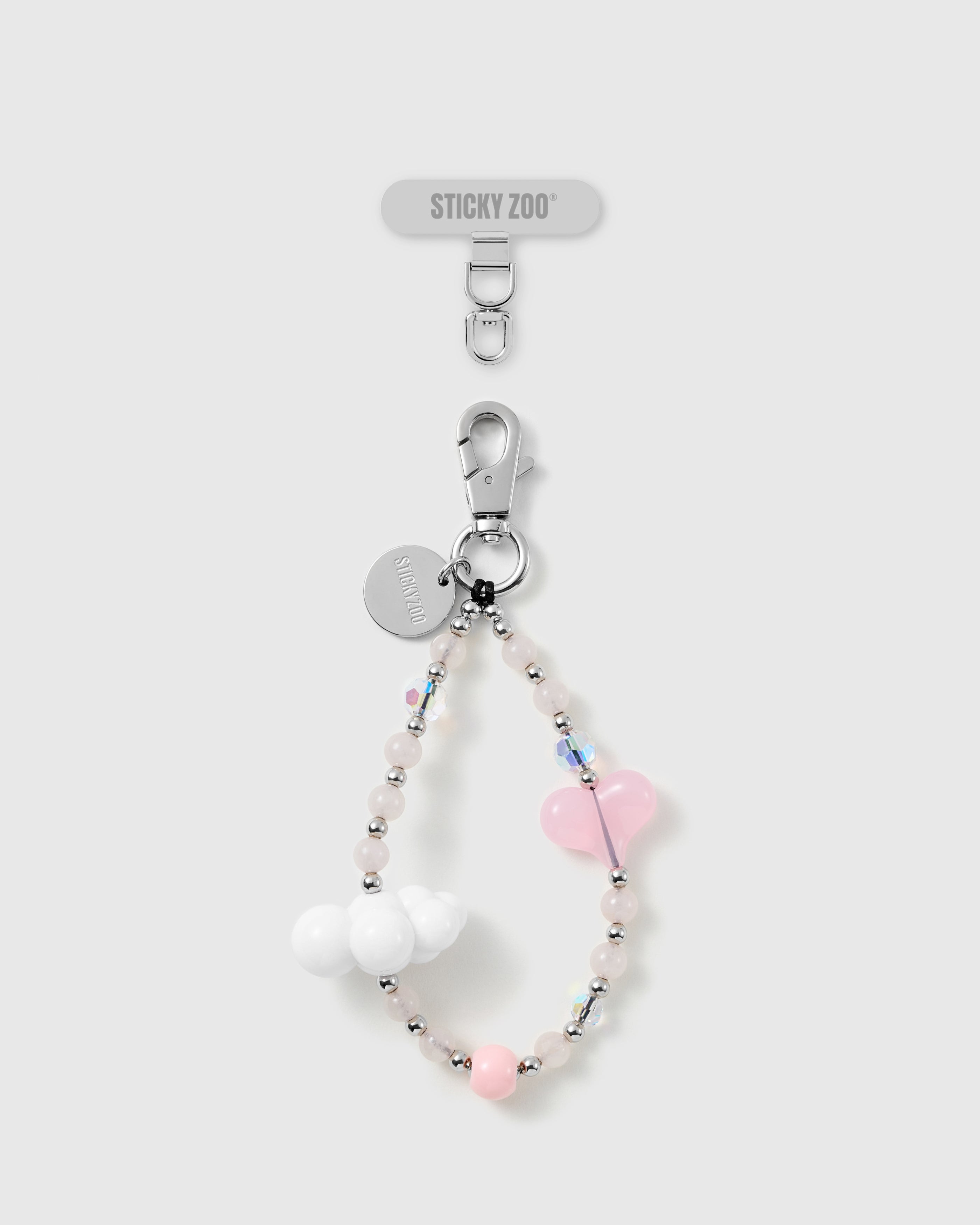 Handmade pastel pink heart and cloud bead phone strap by STICKYZOO with silver-tone engraved hardware, shown with the Phone Strap Card
