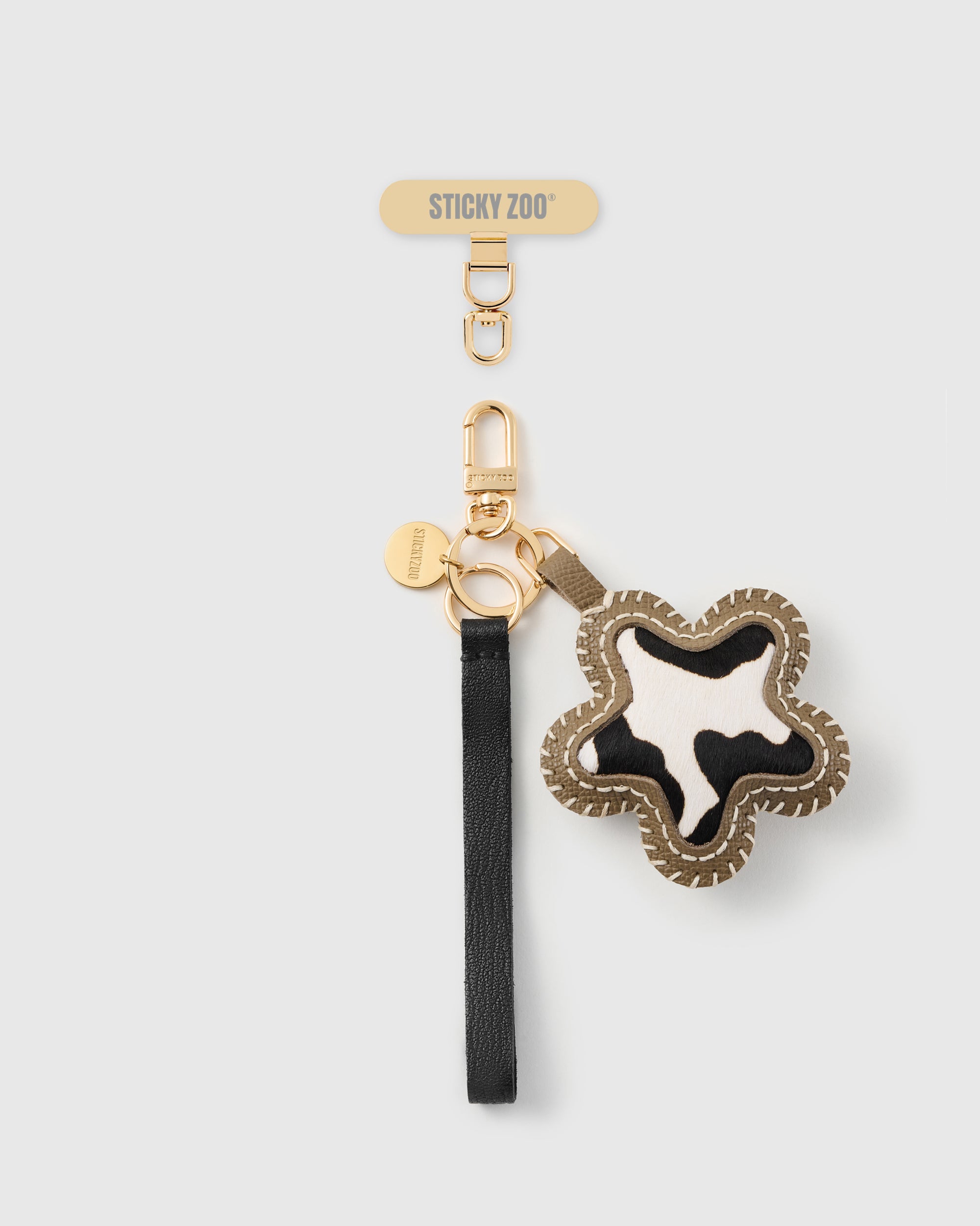 STICKYZOO cow star leather phone strap, black strap with black-and-white calf-hair star and gold hook