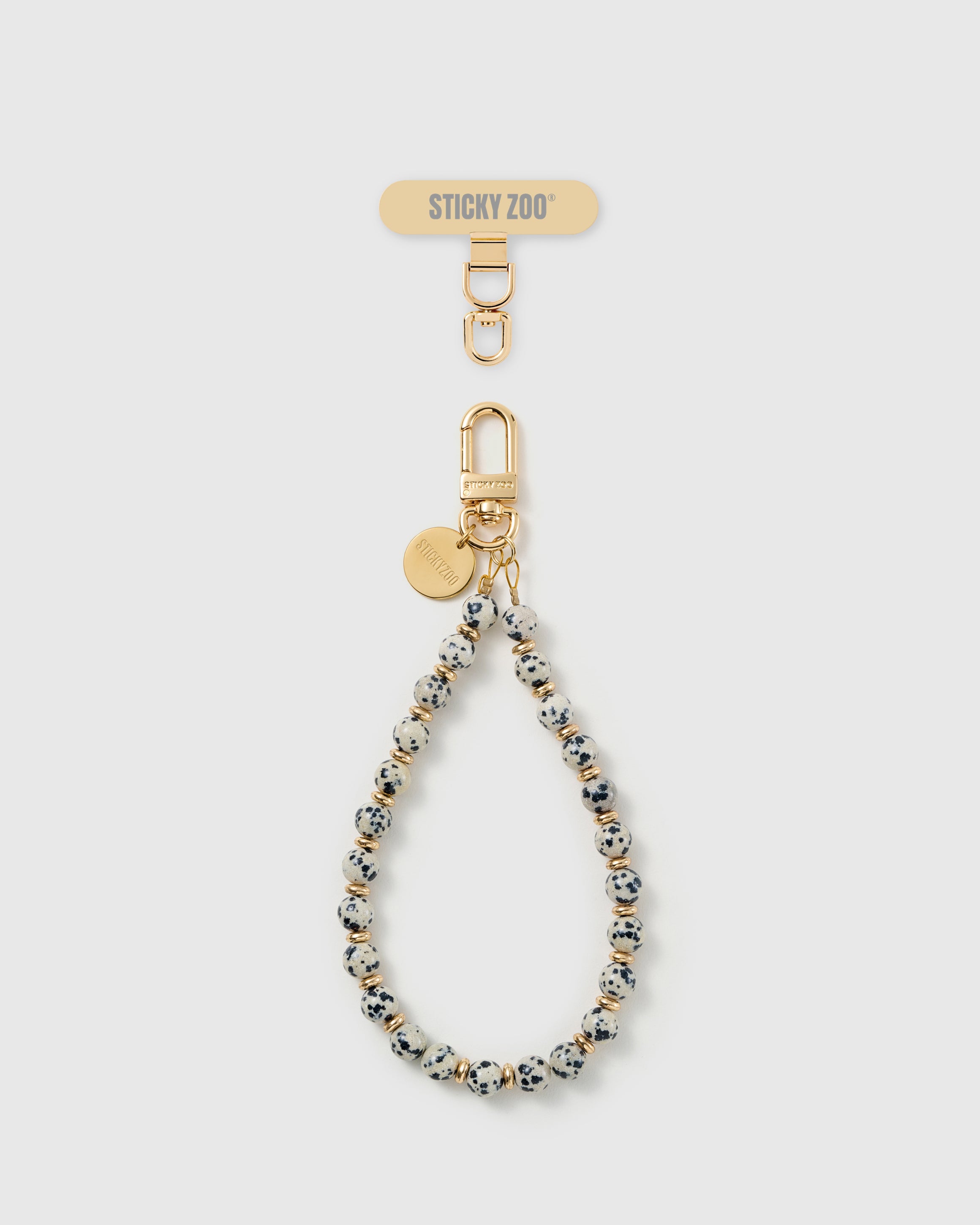 Handmade cream speckled real stone phone strap by STICKYZOO with 18K gold-plated engraved hardware