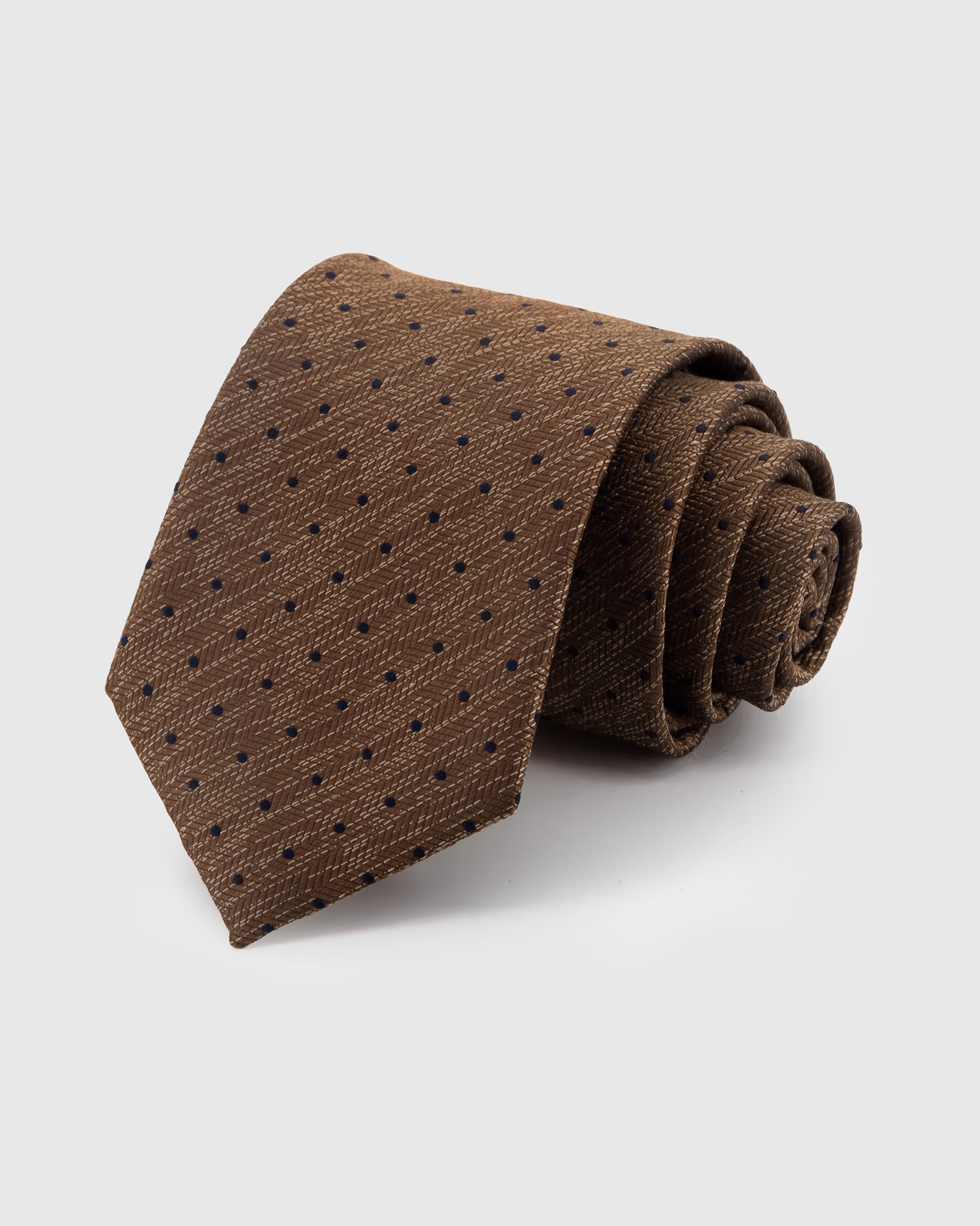 STICKYZOO Caramel Pindot Tie in hand-embroidered mulberry silk with navy pin dots on caramel woven-texture ground, 45° bias-cut Italian method