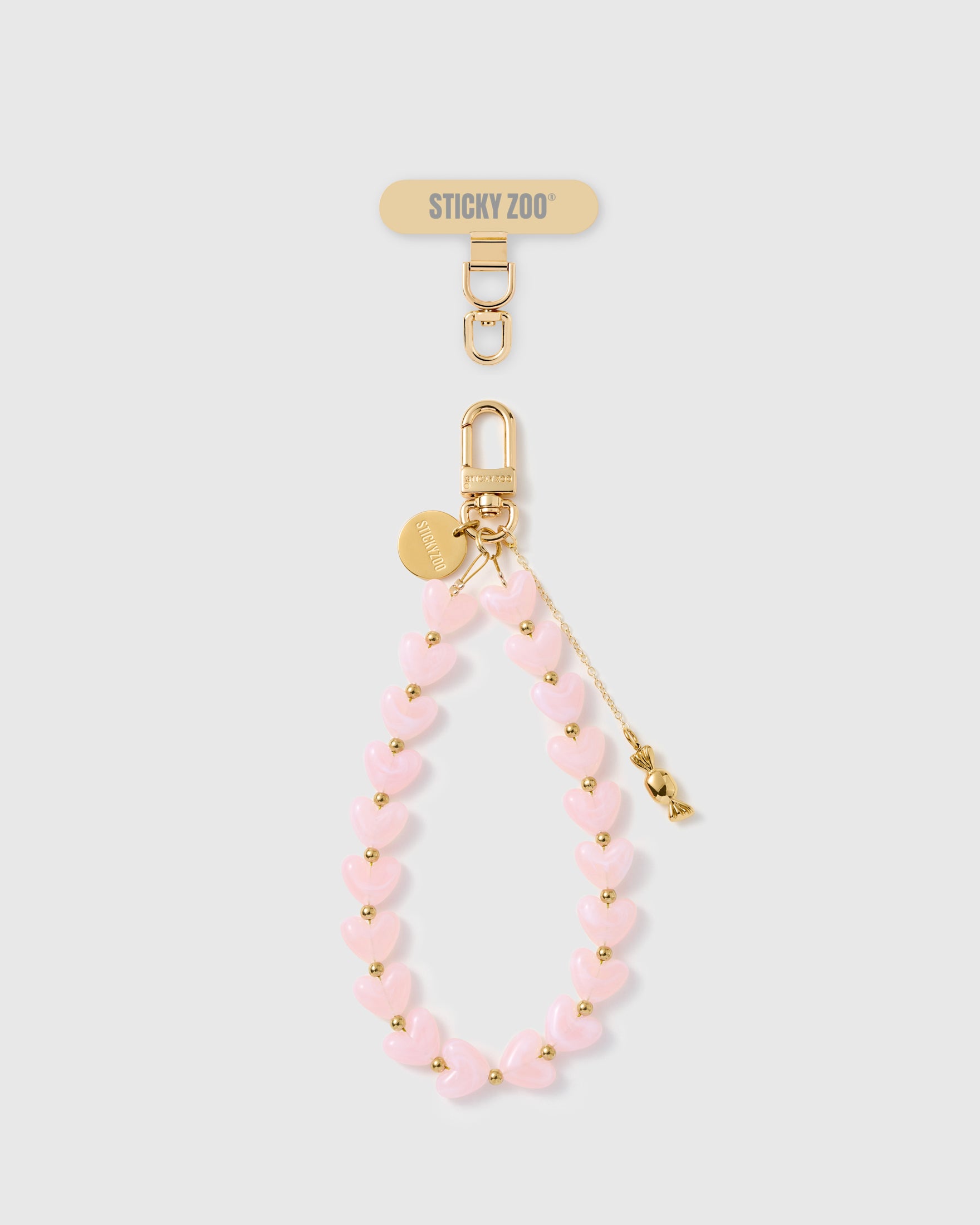 Handmade pearlescent pink heart phone strap with gold candy charm and 18K gold hardware engraved STICKYZOO