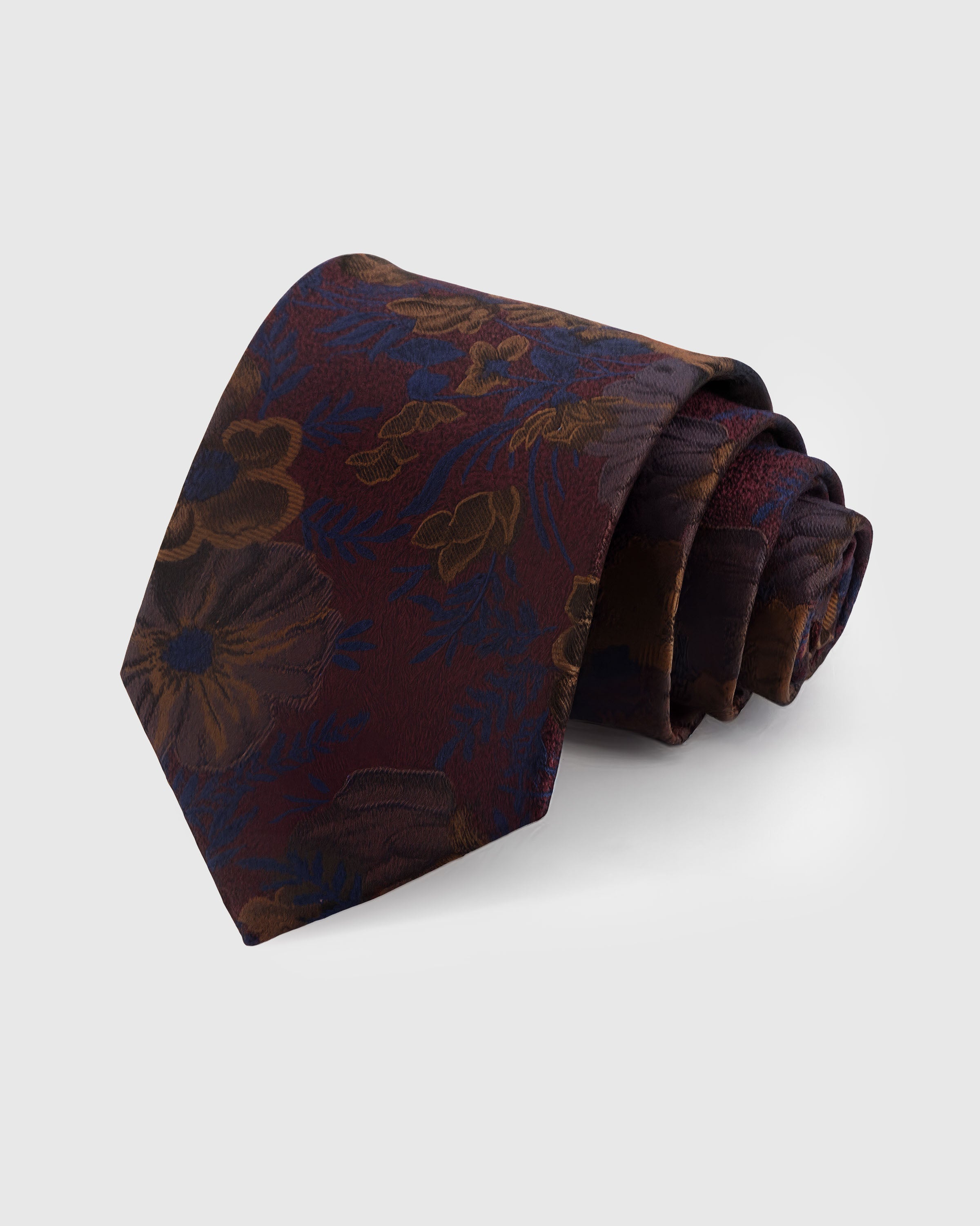 STICKYZOO BORDEAUX BLOSSOM TIE — 100% mulberry silk with hand-embroidered bronze and navy botanical blooms with blue fronds on deep bordeaux wine ground
