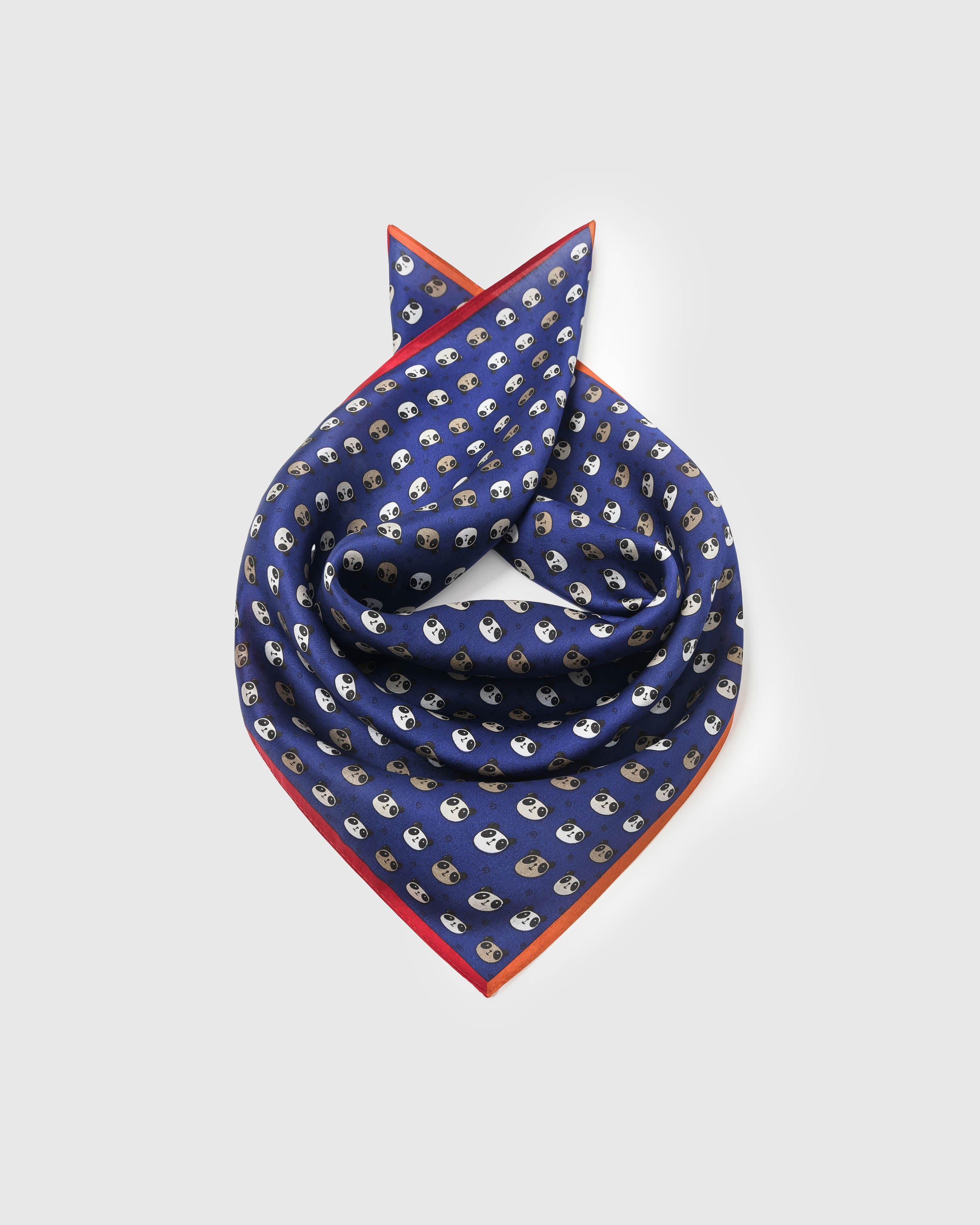 Silk panda scarf coiled into a soft square showing the drape and the red-orange frame catching the light