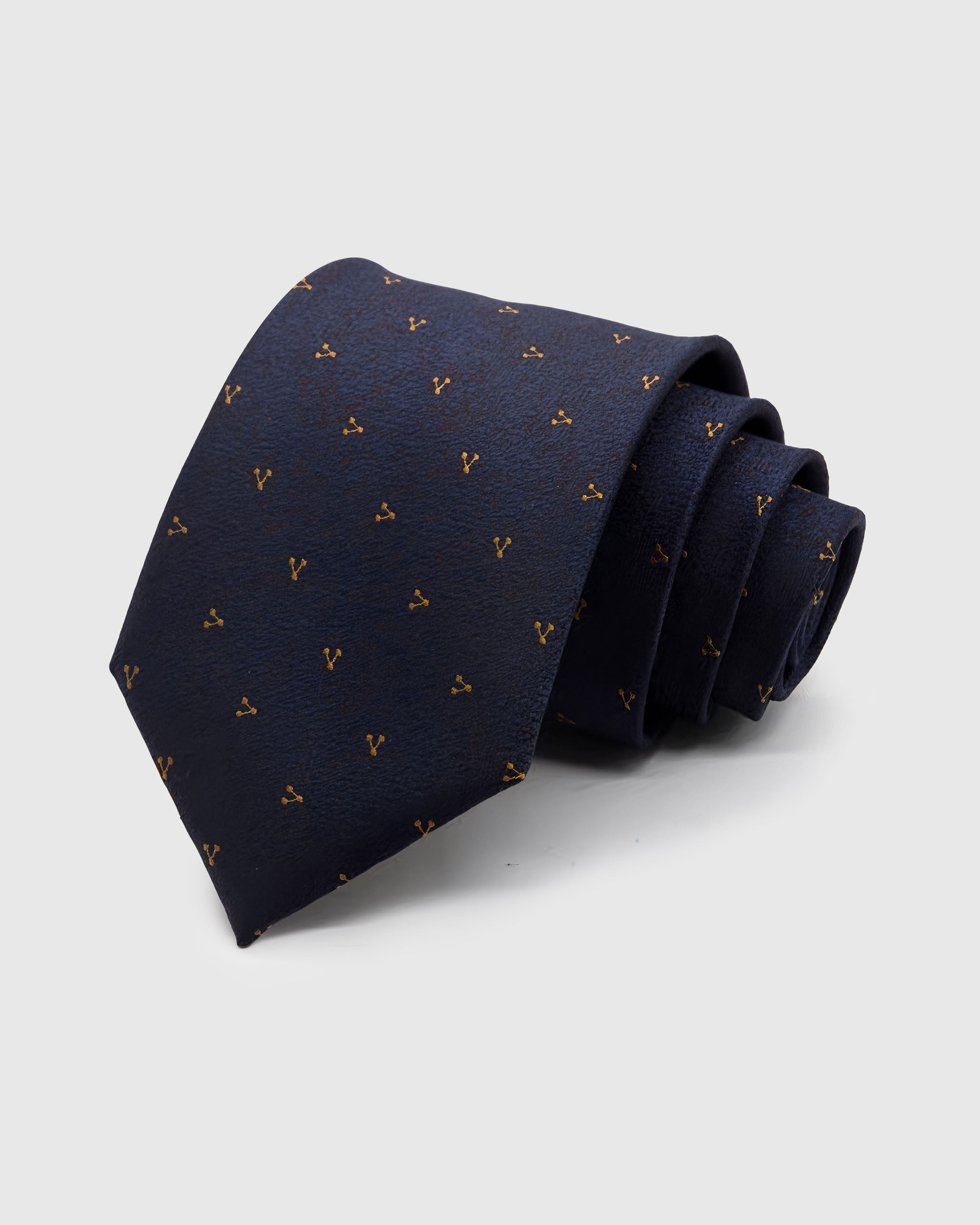 MIDNIGHT SPRIG TIE — Hand-embroidered micro motif detail on 100% mulberry silk in midnight navy, showing embroidery texture and silk sheen