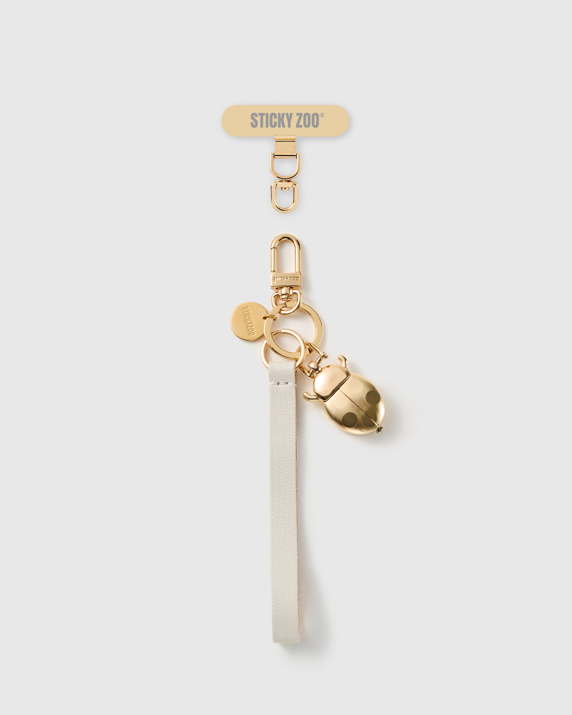 STICKYZOO golden ladybug leather phone strap — ivory Alran strap, gold-plated beetle charm and hardware