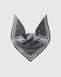 Black and white silk scarf draped to show the soft fall of the polka-dot field and the stripe border