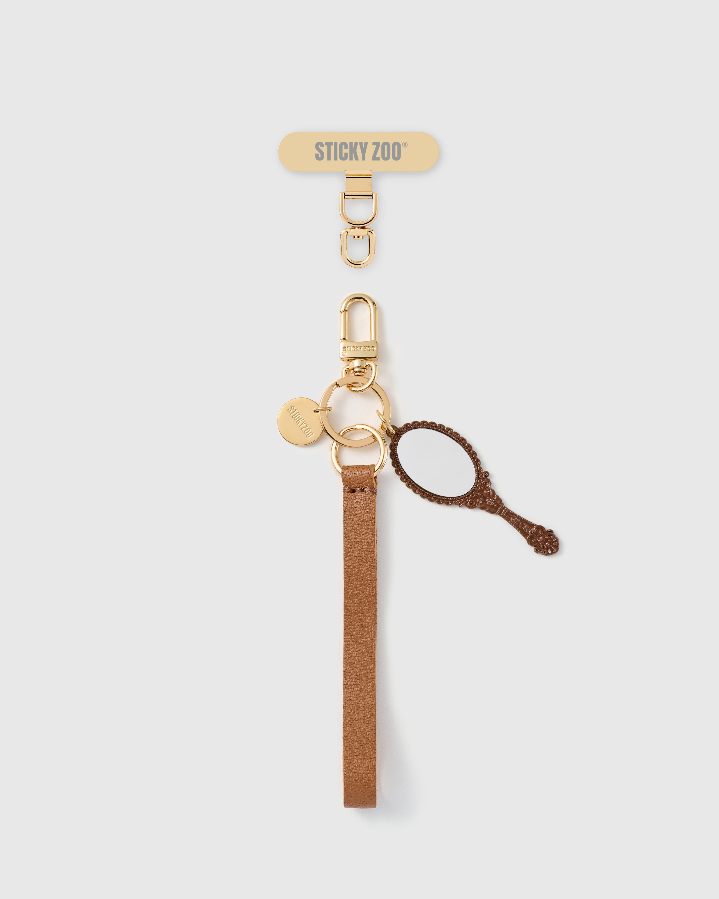 Handmade French Alran cocoa tan leather phone strap with vintage hand-mirror charm featuring ornate handle and 18K gold STICKYZOO hardware