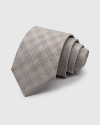 SILVER HOUNDSTOOTH TIE — Hand-embroidered houndstooth detail on 100% mulberry silk in silver, showing embroidery texture and silk sheen