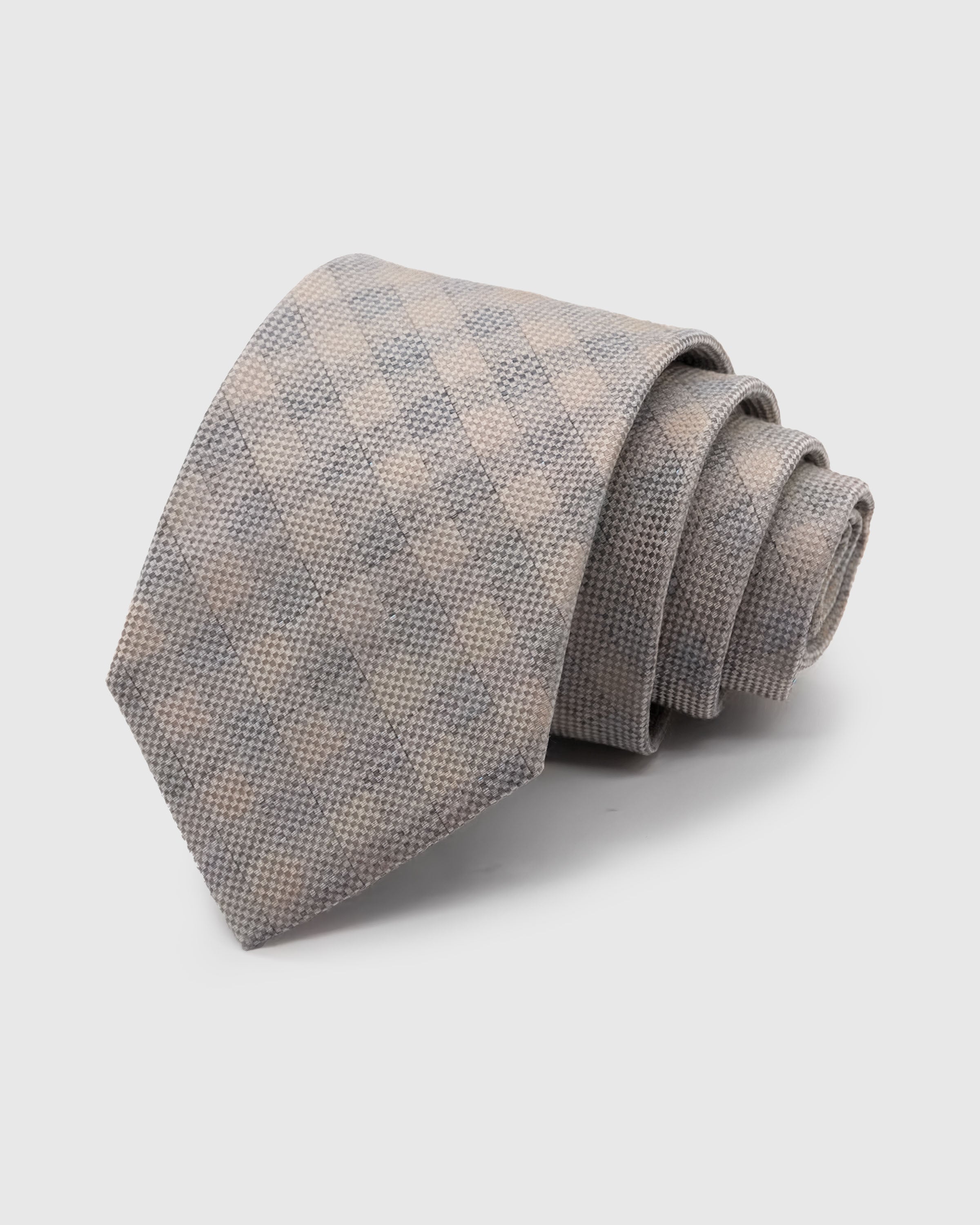 SILVER HOUNDSTOOTH TIE — Hand-embroidered houndstooth detail on 100% mulberry silk in silver, showing embroidery texture and silk sheen
