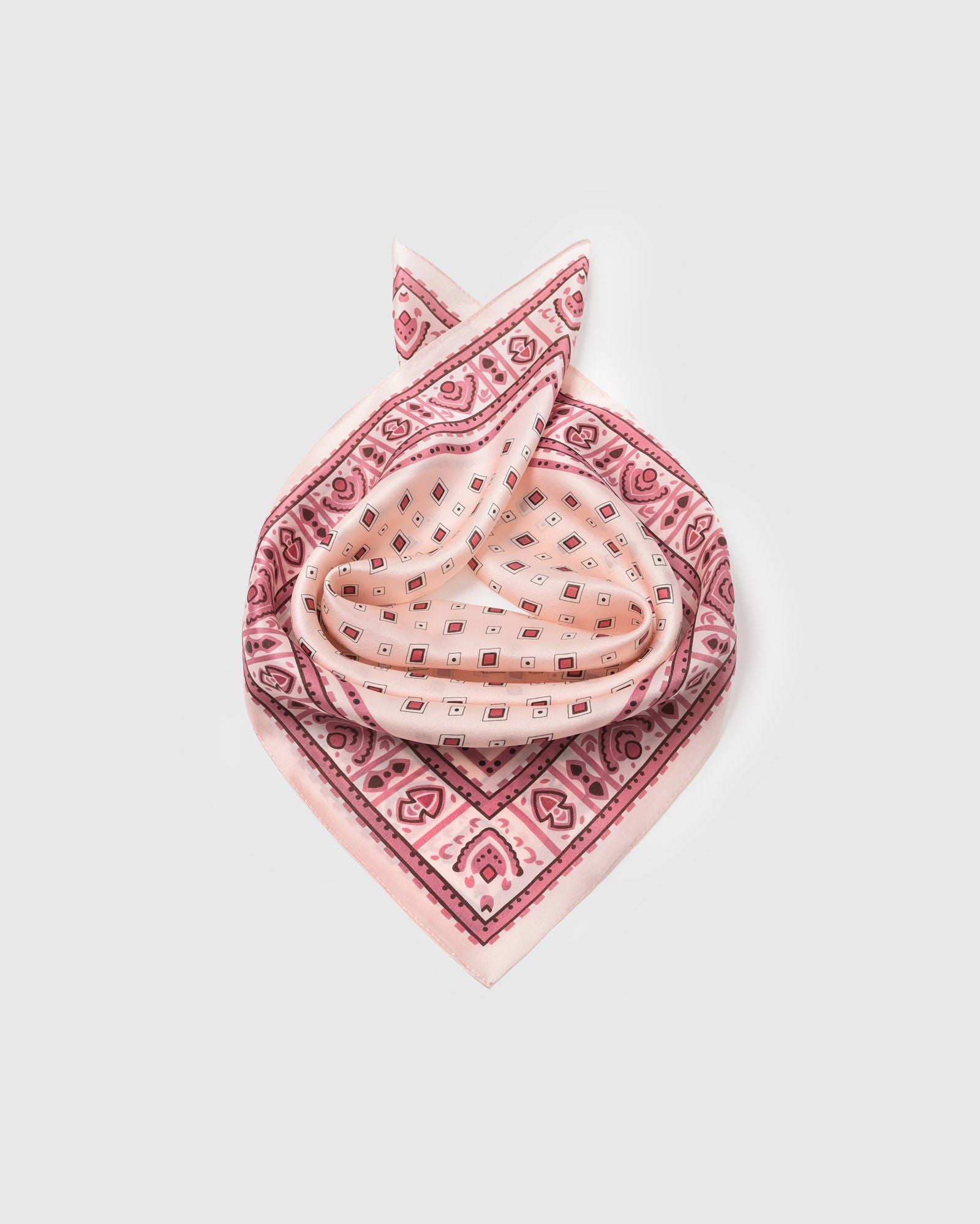 Silk tile scarf coiled to show the pure silk drape and the raspberry-on-blush print
