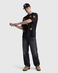 Model in black Poodle Parade T-Shirt angled pose showing plush poodle appliques